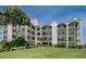 Three-story condominium building with balconies and lush landscaping at 308 Mariner Dr # 308, Tarpon Springs, FL 34689