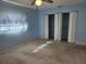 Blue bedroom with carpet, large closet, and window coverings at 119 Stafford Dr, Palm Harbor, FL 34684