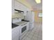 Bright kitchen with white cabinets, appliances, and tile floor at 119 Stafford Dr, Palm Harbor, FL 34684