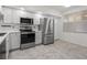 Well-lit kitchen featuring stainless steel appliances, white cabinets, and tiled flooring at 960 Starkey Rd # 5203, Largo, FL 33771