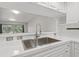 Close up of stainless sink with modern fixtures, set into white countertop, and backsplash at 960 Starkey Rd # 5203, Largo, FL 33771