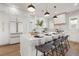 Modern white kitchen with marble island, stainless steel appliances, and herringbone backsplash at 125 48Th N Ave, St Petersburg, FL 33703