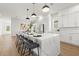 Modern white kitchen with marble island, stainless steel appliances, and herringbone backsplash at 125 48Th N Ave, St Petersburg, FL 33703