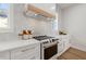 Modern kitchen with white cabinets, marble countertops, and a herringbone backsplash at 125 48Th N Ave, St Petersburg, FL 33703