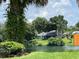 Charming backyard view showcasing a waterfront property and lush green landscape at 4922 Lake Valencia W Blvd, Palm Harbor, FL 34684