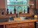 Kitchen sink featuring wood cabinets, decorative tile backsplash and window view at 4922 Lake Valencia W Blvd, Palm Harbor, FL 34684