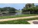 Scenic view of the tranquil lake reflecting the sky, complemented by a rustic wooden fence at 4922 Lake Valencia W Blvd, Palm Harbor, FL 34684