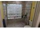 Tiled shower featuring a glass block window, offering privacy and natural light at 4922 Lake Valencia W Blvd, Palm Harbor, FL 34684