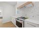 Modern kitchen with white cabinets and a unique hexagonal tile backsplash at 135 48Th Ave, St Petersburg, FL 33703