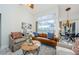 Spacious living room with leather couch and large windows overlooking pool at 957 Westwinds Blvd, Tarpon Springs, FL 34689