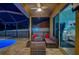 Covered patio with firepit and comfortable seating near the pool at 957 Westwinds Blvd, Tarpon Springs, FL 34689