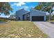 Modern two-story home with dark garage door and landscaped yard at 2000 Brent Pl, Palm Harbor, FL 34683