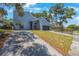 Contemporary gray home with a long driveway and mature trees at 2000 Brent Pl, Palm Harbor, FL 34683