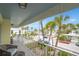 Balcony showcasing seating, charming views of palm trees, and the ocean in the distance at 108 14Th Ave # 3, St Pete Beach, FL 33706