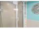 Updated bathroom with a glass shower and linen closet with turquoise walls at 108 14Th Ave # 3, St Pete Beach, FL 33706