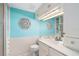 Bright bathroom with white cabinets and sink with a blue accent wall at 108 14Th Ave # 3, St Pete Beach, FL 33706