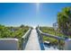 Wooden boardwalk leading to a pristine beach with clear blue skies and the ocean in the background at 108 14Th Ave # 3, St Pete Beach, FL 33706