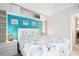 Bright bedroom featuring a blue accent wall and built-in shelving over the white headboard at 108 14Th Ave # 3, St Pete Beach, FL 33706