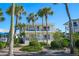 A front view of a two-story condo building surrounded by tropical landscaping and palm trees at 108 14Th Ave # 3, St Pete Beach, FL 33706