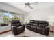 Cozy living room featuring leather seating, ceiling fan, and sun-drenched window with a view of palm trees at 108 14Th Ave # 3, St Pete Beach, FL 33706