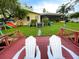 Red wooden dock with white Adirondack chairs at 1964 Arvis E Cir, Clearwater, FL 33764