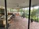 Relaxing screened patio with herringbone tile and outdoor seating at 1964 Arvis E Cir, Clearwater, FL 33764