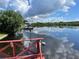 Calm waterfront view with a red dock and lush vegetation at 1964 Arvis E Cir, Clearwater, FL 33764