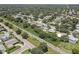 Aerial view of a residential neighborhood with houses, pools, and lush green spaces near a railway at 2098 Swan Ln, Safety Harbor, FL 34695