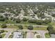 Aerial view of a residential neighborhood with houses, pools, and lush green spaces near a railway at 2098 Swan Ln, Safety Harbor, FL 34695