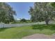 Fenced backyard with large lawn and mature trees at 2098 Swan Ln, Safety Harbor, FL 34695