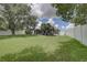 Expansive grassy backyard with mature trees and a wooden deck at 2098 Swan Ln, Safety Harbor, FL 34695