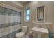 Clean bathroom with shower/tub combo, pedestal sink, and decorative mirror at 2098 Swan Ln, Safety Harbor, FL 34695