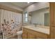 Main bathroom with shower, wood vanity, and floral shower curtain at 2098 Swan Ln, Safety Harbor, FL 34695