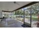 Relaxing screened porch with tiled floor, ceiling fan, and access to backyard at 2098 Swan Ln, Safety Harbor, FL 34695