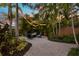 Inviting backyard patio with elegant string lights, lush tropical landscaping, and a comfortable seating area around a fire pit at 546 18Th Ne Ave, St Petersburg, FL 33704