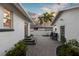 Backyard area with brick pavers, outdoor table and chairs, palm trees, and lush vegetation at 546 18Th Ne Ave, St Petersburg, FL 33704