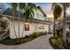 Backyard area with brick pavers, palm trees, lush vegetation, and the home's exterior at dusk at 546 18Th Ne Ave, St Petersburg, FL 33704