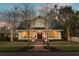 Stunning home exterior with a welcoming front porch, manicured lawn, and elegant lighting creating a warm ambiance at 546 18Th Ne Ave, St Petersburg, FL 33704