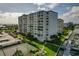 Aerial view of waterfront condo building with tennis courts, pool, and boat slips at 660 Island Way # 301, Clearwater Beach, FL 33767