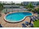 Relaxing kidney-shaped pool with lounge chairs and tennis courts at 660 Island Way # 301, Clearwater Beach, FL 33767