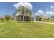 Two-story house with palm trees, landscaped lawn, and driveway at 879 De Soto Way, Tarpon Springs, FL 34689