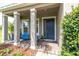 Covered front porch with blue chairs and tile floor at 879 De Soto Way, Tarpon Springs, FL 34689