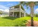 Two-story house back elevation, with patio and fenced backyard at 879 De Soto Way, Tarpon Springs, FL 34689