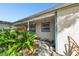 Cozy front porch area featuring colorful hanging plants and decorative accents by the home's entryway at 253 Sunlit Cove Ne Dr, St Petersburg, FL 33702