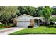 Single-story house with a two-car garage and nicely landscaped lawn at 3529 Tanglewood Trl, Palm Harbor, FL 34685