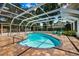 Enclosed pool area features a shimmering in-ground pool, brick pavers, and lounge chairs at 1549 Linwood Dr, Clearwater, FL 33755