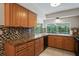 Kitchen with wood cabinets, granite counters, and tile backsplash at 12912 Willoughby Ln, Hudson, FL 34667
