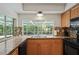 Kitchen boasts wood cabinets, granite countertops, and pool view at 12912 Willoughby Ln, Hudson, FL 34667