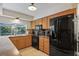Kitchen features wood cabinets, black appliances, and granite counters at 12912 Willoughby Ln, Hudson, FL 34667