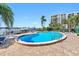 Relaxing kidney-shaped pool with lounge chairs; waterfront building in background at 660 Island Way # 401, Clearwater, FL 33767